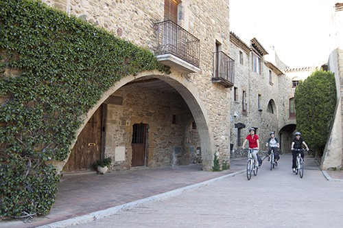 cyclists cycling through an old town